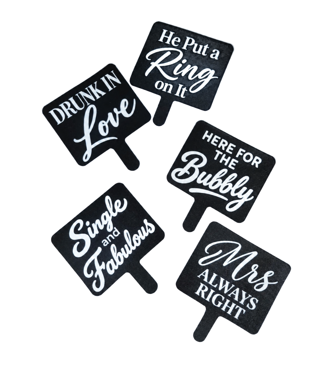 Five black 3D printed photo booth signs with raised white lettering reading He Put a Ring on It, Drunk in Love, Here for the Bubbly, Single and Fabulous and Mrs Always Right