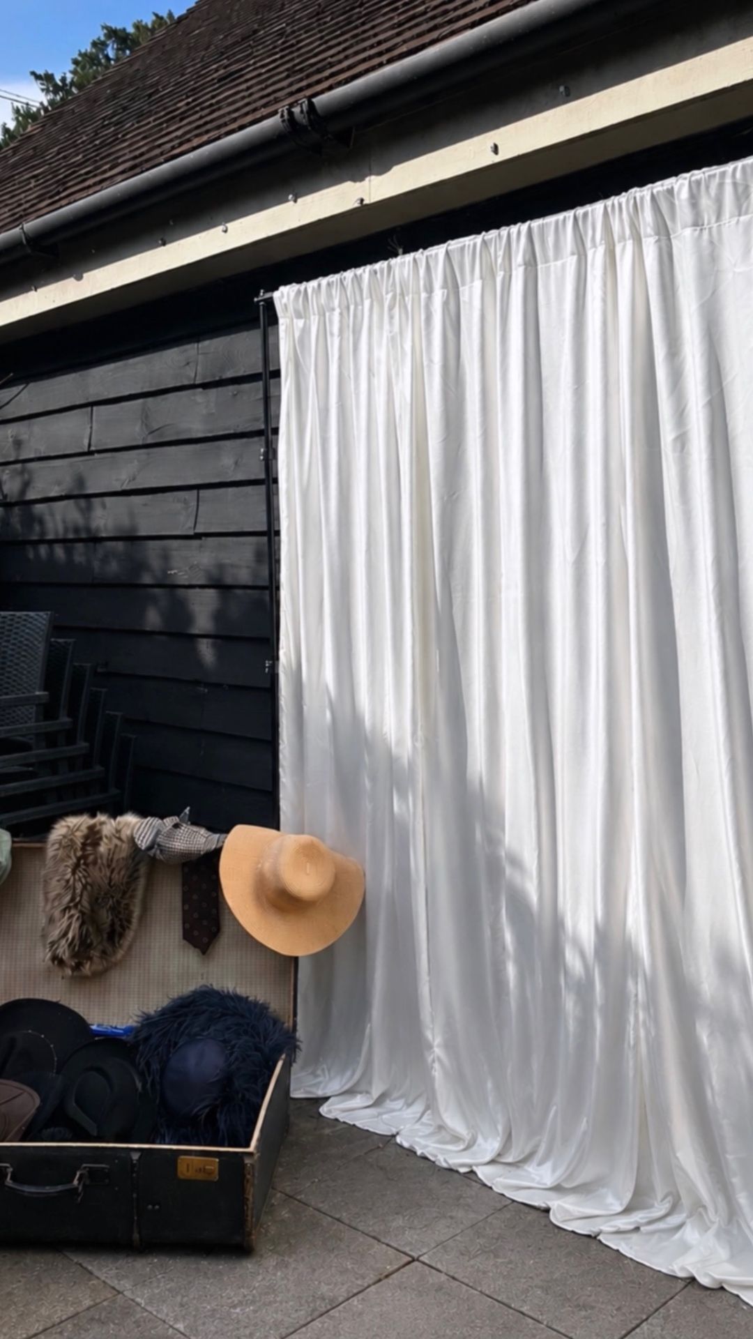 Freestanding booth cream curtain backdrop with vintage prop suitcase