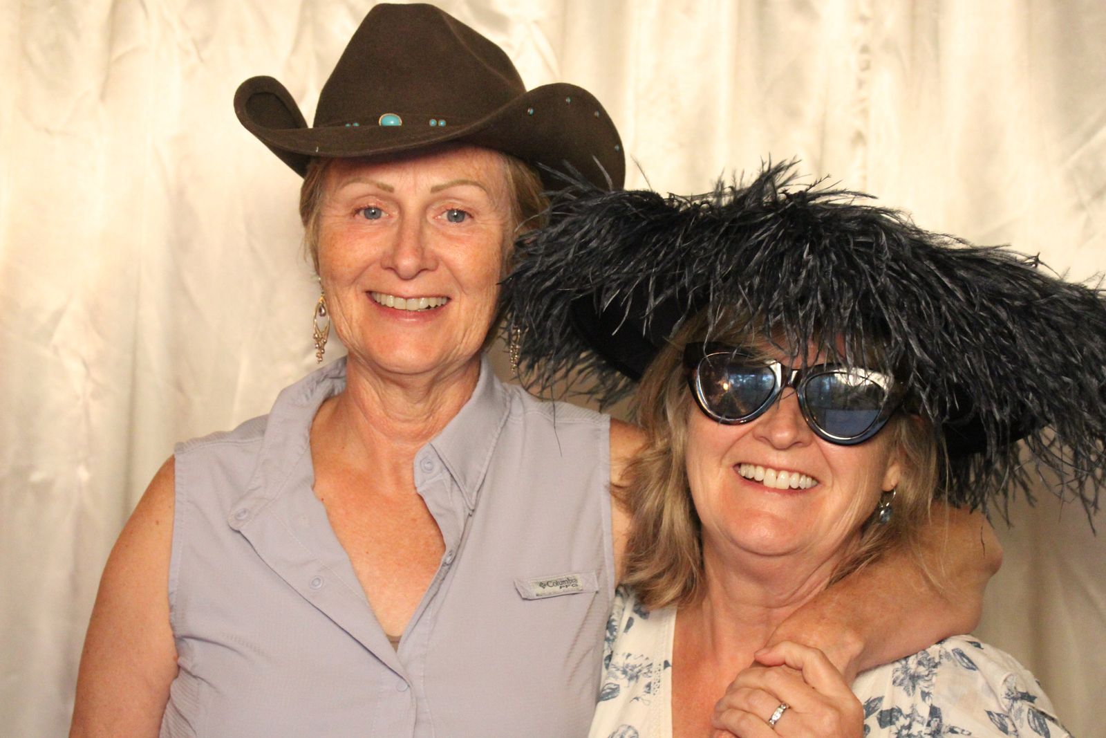 Two friends in a cowboy hat and feathered hat with sunglasses